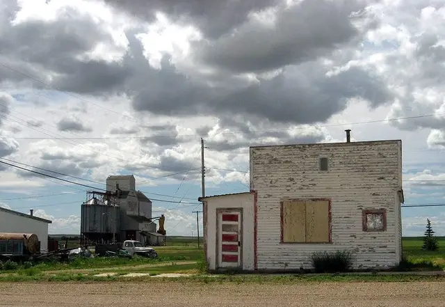 Old weathered building and grain elevator in Neville
